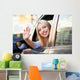 Young woman waving from car window Wall Mural