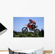 red and orange moto x or motor cross bike giving big air on dirt Wall Mural
