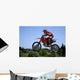 red and orange moto x or motor cross bike giving big air on dirt Wall Mural