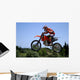 red and orange moto x or motor cross bike giving big air on dirt Wall Mural