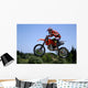 red and orange moto x or motor cross bike giving big air on dirt Wall Mural