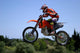 red and orange moto x or motor cross bike giving big air on dirt Wall Mural