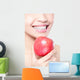 young woman eating red apple with health teeth Wall Mural