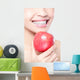 young woman eating red apple with health teeth Wall Mural