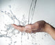 human hands with water splashing on them Wall Mural