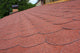 Red asphalt shingle roofing on a roof and chimney Wall Mural