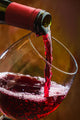 Wine pours into the glass of the bottle Wall Mural