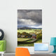 Grass fields and autumn coloured trees under storm clouds Wall Mural