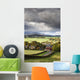 Grass fields and autumn coloured trees under storm clouds Wall Mural