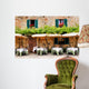 Cafe tables and chairs outside a stone building in Tuscany Wall Mural