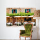 Cafe tables and chairs outside a stone building in Tuscany Wall Mural