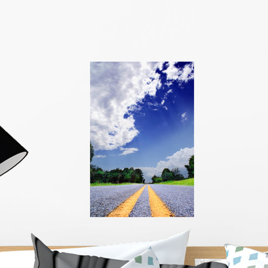 Country-road under a dramatically lighted cloudy sky Wall Mural