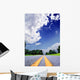 Country-road under a dramatically lighted cloudy sky Wall Mural
