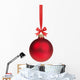 red christmas ball hanging on ribbon with bow 