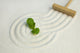 Green leaf on raked white sand of a zen garden Wall Mural