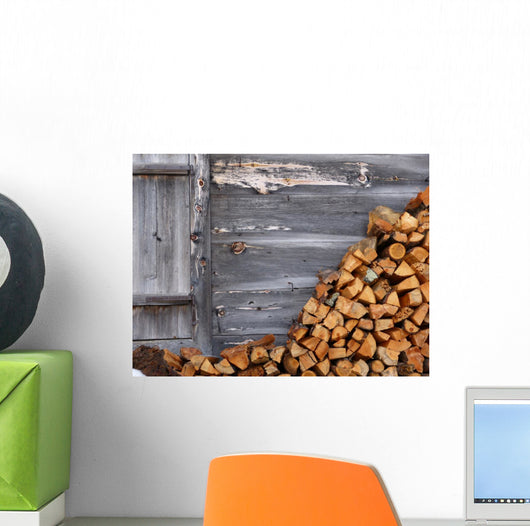 Firewood to the wooden wall of a hut 