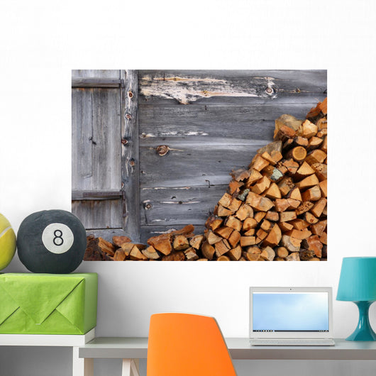 Firewood to the wooden wall of a hut 