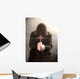 A monk praying with a rosary and crucifix in his hand. Wall Mural
