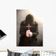 A monk praying with a rosary and crucifix in his hand. Wall Mural
