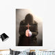 A monk praying with a rosary and crucifix in his hand. Wall Mural