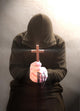 A monk praying with a rosary and crucifix in his hand. Wall Mural