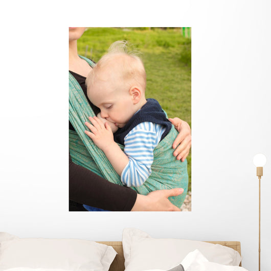 Breastfeeding in baby sling outdoors 