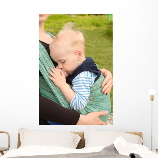 Breastfeeding in baby sling outdoors 