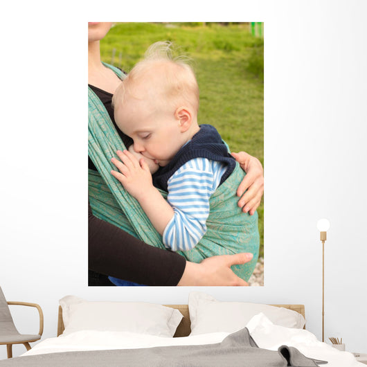 Breastfeeding in baby sling outdoors 