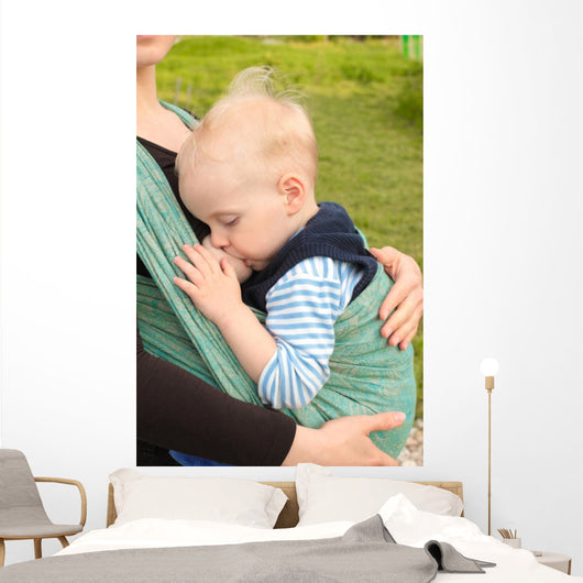 Breastfeeding in baby sling outdoors 
