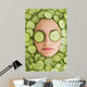 Beautiful woman with facial mask of cucumber slices on face Wall Mural