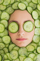Beautiful woman with facial mask of cucumber slices on face Wall Mural
