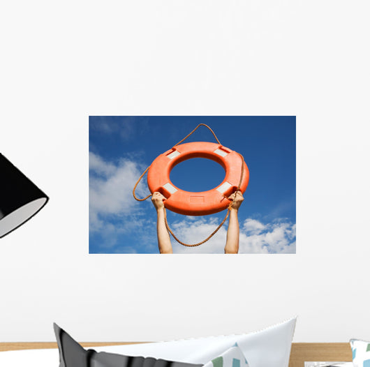 Life buoy ring in man's hands on a background of the sky. Wall Mural