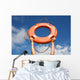 Life buoy ring in man's hands on a background of the sky. Wall Mural