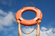 Life buoy ring in man's hands on a background of the sky. Wall Mural