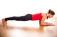 Young woman exercising - doing a plank in a studio 