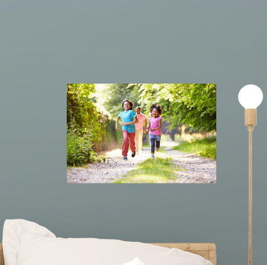 Children Running In Countryside With Father 