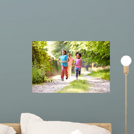 Children Running In Countryside With Father 