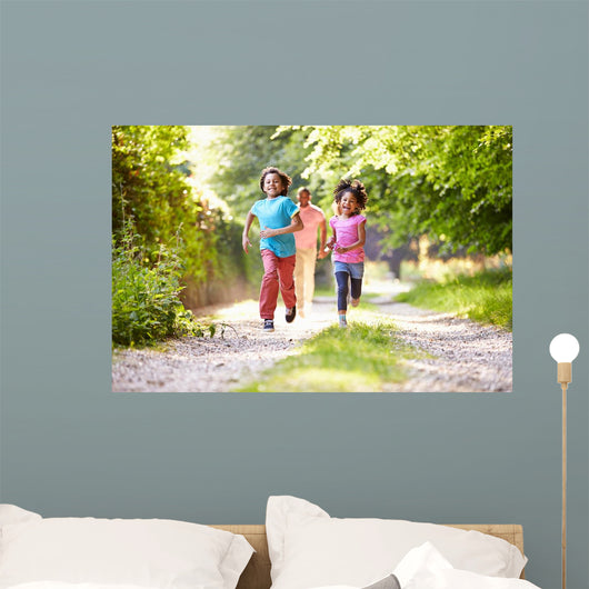 Children Running In Countryside With Father 