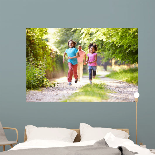 Children Running In Countryside With Father 