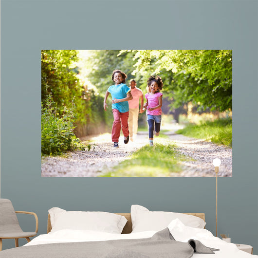 Children Running In Countryside With Father 