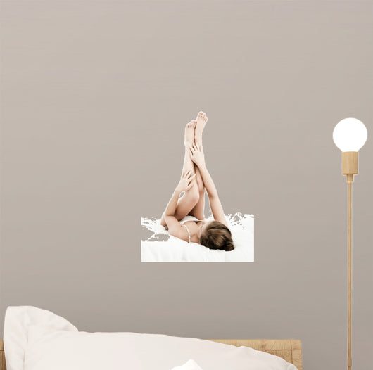 Woman massaging legs lying on white background 