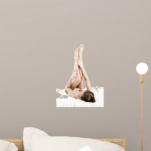 Woman massaging legs lying on white background 