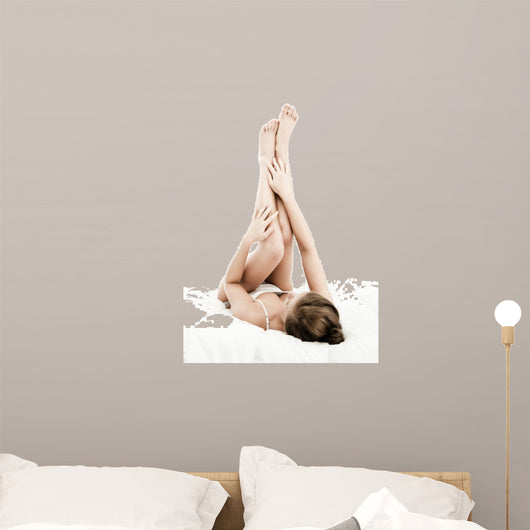 Woman massaging legs lying on white background 