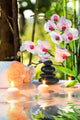 massage composition spa with candles, orchids, stones in garden Wall Mural