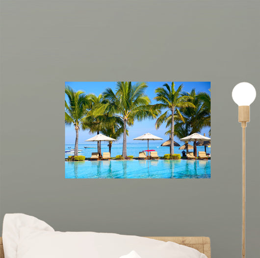 Swimming pool with  umbrellas on beach in Mauritius Wall Mural