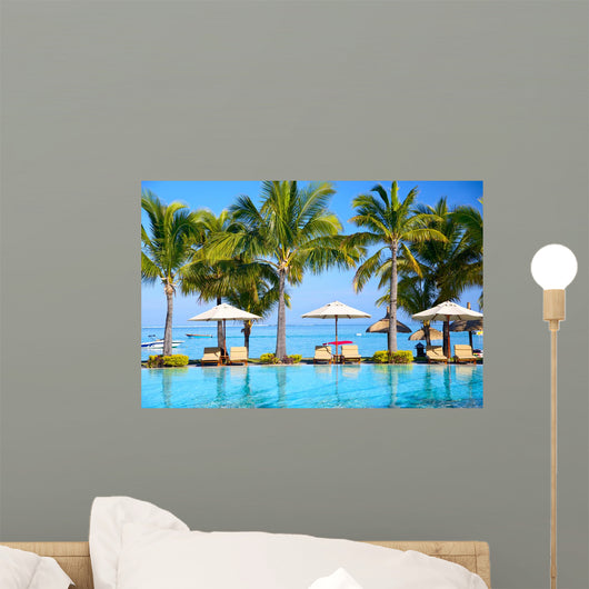 Swimming pool with  umbrellas on beach in Mauritius Wall Mural