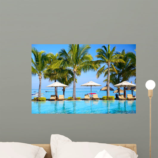 Swimming pool with  umbrellas on beach in Mauritius Wall Mural