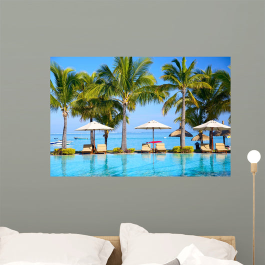 Swimming pool with  umbrellas on beach in Mauritius Wall Mural