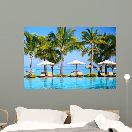Swimming pool with  umbrellas on beach in Mauritius Wall Mural