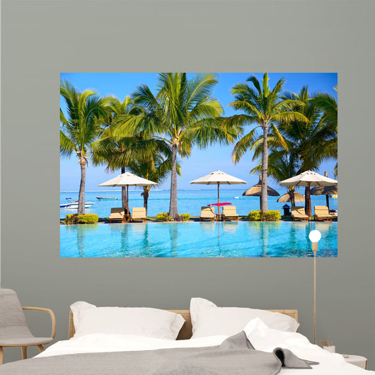 Swimming pool with  umbrellas on beach in Mauritius Wall Mural